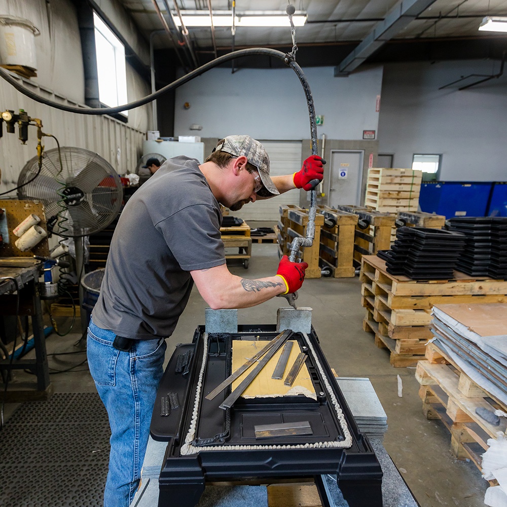 A HearthStone tech assembles and builds a cast iron wood stove in Morrisville, Vermont